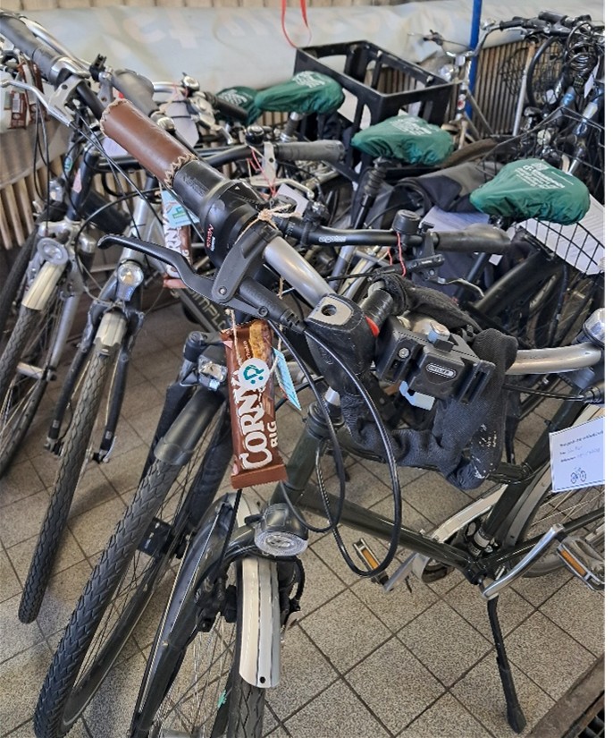 Mehrere Fahrräder an einem hängt ein Corny mit P Faktor Aufkleber