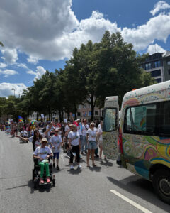 Viele Personen hinter CSD-Bus